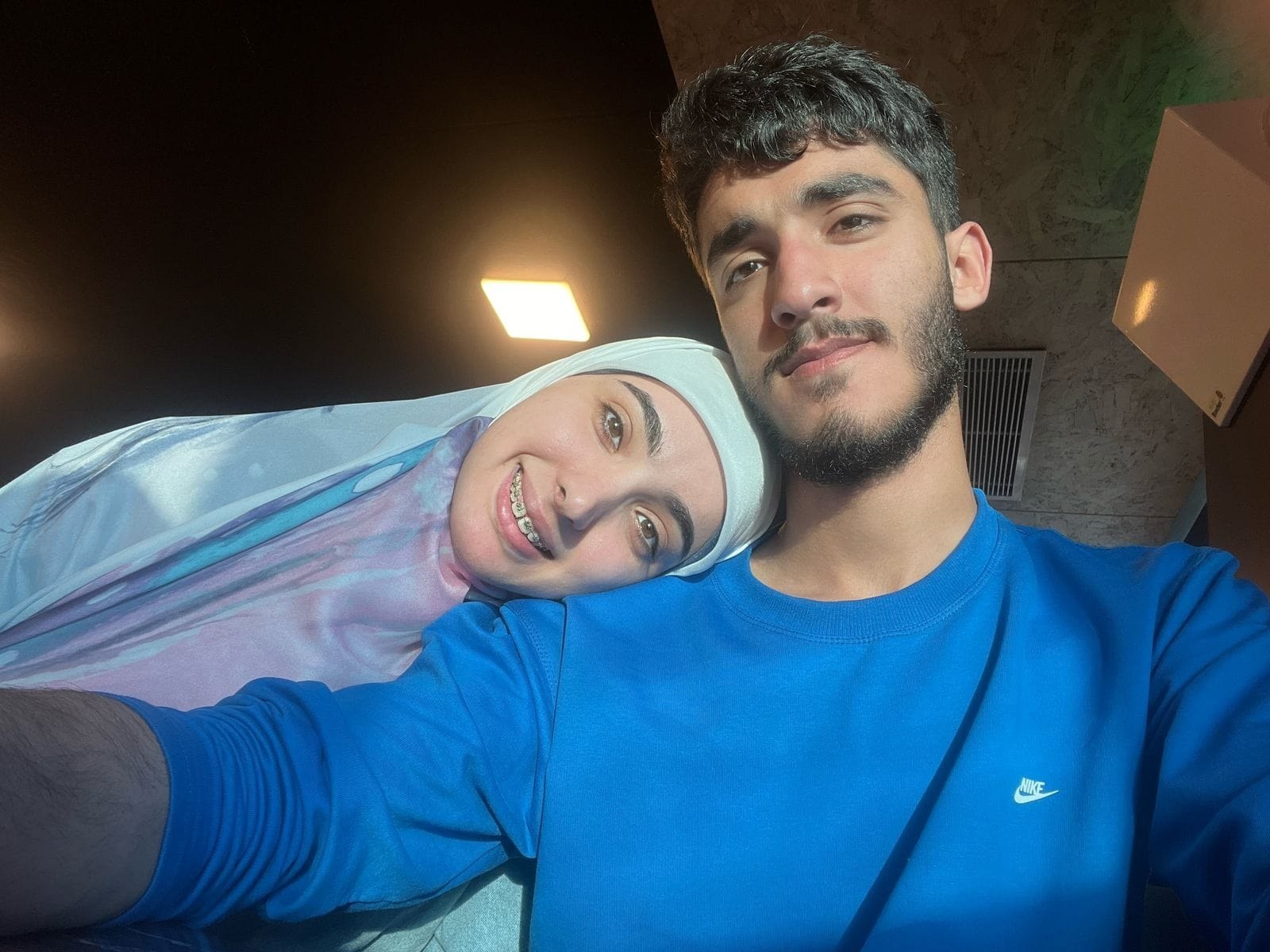 Alaa resting her head on her brother’s shoulder
